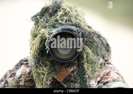 der Naturfotograf mit Tarnung und seine riesige 300mm 2.8 Teleobjektiv auf Sie gerichtet, während draußen Stockfoto