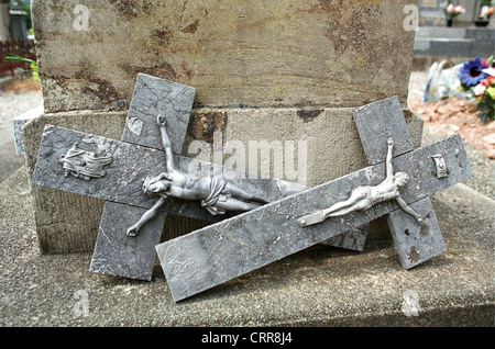 Zwei steinerne Kreuze mit Jesus-Figuren auf einem Friedhof Stockfoto