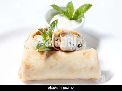 Dessert. Palatschinken mit Quark und Rosinen in Puderzucker. Stockfoto