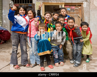 Eine Gruppe Bande von lächelnden jungen Uyghur chinesische Kinder posieren für die Kamera auf der Straße in der alten Stadt Kashgar. Stockfoto