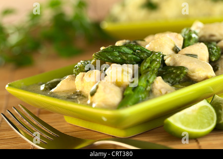 Grüner Spargel und Hähnchen Frikassee mit Limettenscheiben in der front Stockfoto