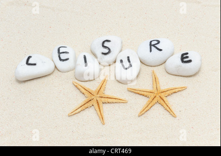 Freizeit-Wort auf Gruppe von Steinen mit Sand Hintergrund mit zwei Seesternen verziert Stockfoto