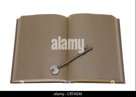 Altes Buch mit einem Schlüssel auf die leeren Seiten isoliert auf weißem Hintergrund geöffnet Stockfoto