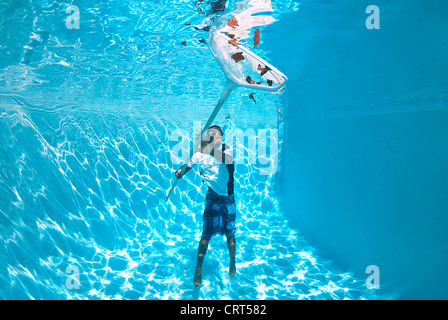 Junger Mann ist der Pool aus dem Wasser mit einem Schaumlöffel net Reinigung Stockfoto