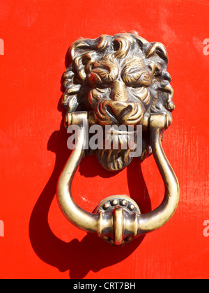 Löwenkopf Türklopfer an rote Tür Stockfoto