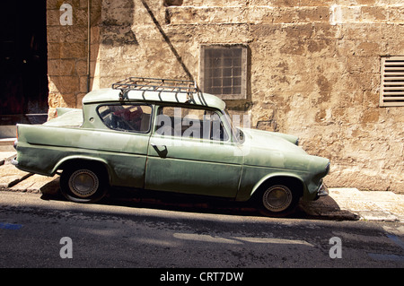 In einer engen Straße von Valletta, der Hauptstadt von Malta ist ein sehr altes Auto geparkt. Stockfoto