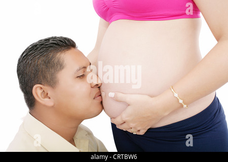 Nahaufnahme eines Mannes, den Bauch seiner schwangeren Frau küssen Stockfoto