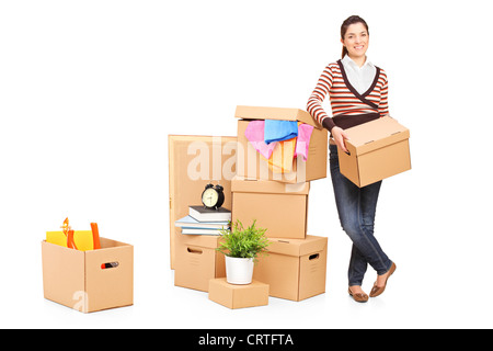 Voller Länge Porträt einer lächelnden Frau Umzug in ein neues Zuhause mit vielen Boxen um sie herum Stockfoto