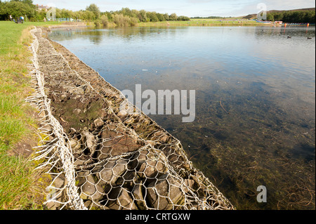 Eingesperrte Rock Riprap in Edelstahl-Rahmen als ein struktureller Baustein Böschung für See einmal ehemaligen Zeche Website verwendet Stockfoto