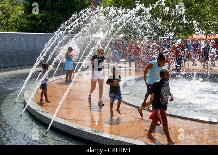 Greensboro, NC. Erwachsene und Kinder finden Abkühlung von der Hitze Hitze im Zentrum City Park Brunnen. Stockfoto