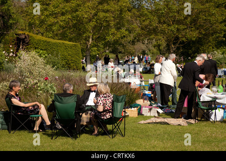 Menschen mit einem Picknick auf der Wiese beim Glyndebourne Opernfestival, Lewes, Sussex UK Stockfoto