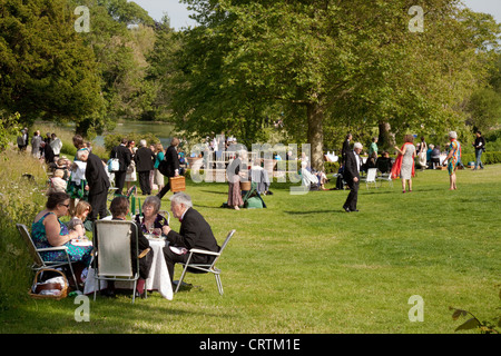 Menschen mit einem Picknick auf der Wiese beim Glyndebourne Opernfestival, Lewes, Sussex UK Stockfoto