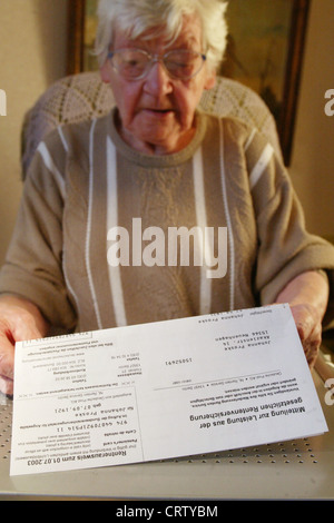 Ein Rentner liest ihre Rente Stockfoto
