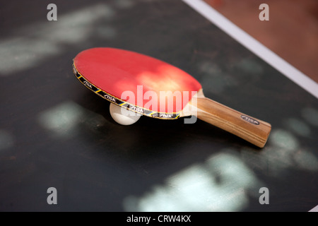 Ping-Pong-Schläger und Ball auf eine Tischtennis-Oberfläche. Stockfoto