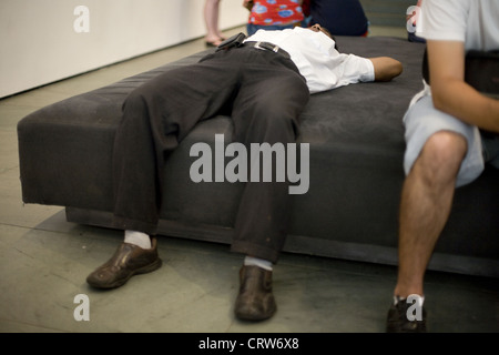 Mann schläft auf dem Sofa im Museum of Modern Art in New York Stockfoto