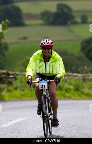 Radfahrer aufsteigend einen steilen Hügel in Garsdale, an der Küste zu Küste Route, North Yorkshire Dales National Park, Großbritannien Stockfoto