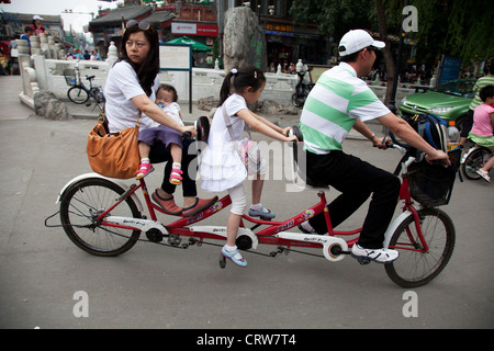 Familie Reiten entlang auf einer dreifachen Tandem-Fahrrad in Shichahai Nähe Yandai Xiejie und Yinding-Brücke, Beijing, China. Stockfoto