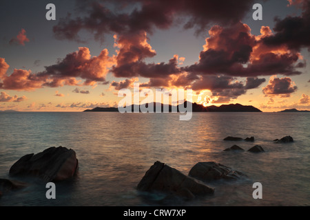 Wolken über der Baie Ste Anne bei Sonnenuntergang vom Nordende von La Digue auf den Seychellen gesehen Stockfoto