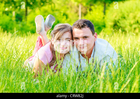 Fröhliche junge schöne Paar liegt auf dem Gebiet und die umliegende Natur zu genießen. Stockfoto