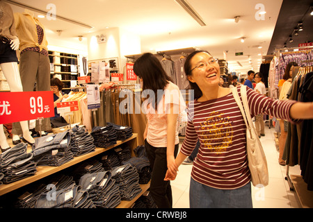 Shopper im Inneren der Uniqlo Store in Joy City Shopping Mall. Xidan ist eines der wichtigsten kommerziellen Einkaufsstraßen in Peking. Stockfoto