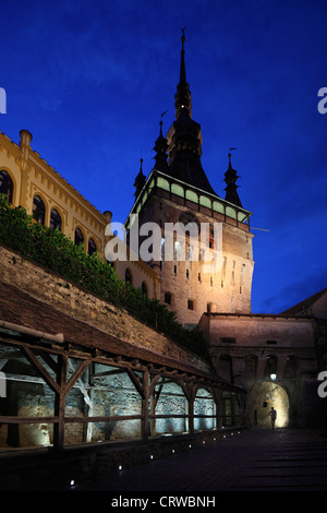 Ein einsamer Touristen steht im Torbogen unter dem Uhrturm in der mittelalterlichen Stadt Sighisoara, Rumänien in der Nacht Stockfoto