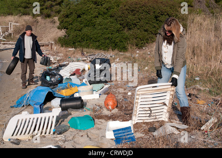 Auf einem kleinen Strand angespülten Müll aufräumen Stockfoto