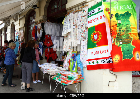 Touristen, Einkaufen, Handtücher für den Strand und Kunsthandwerk hängen außerhalb Souvenir-Shop, Viana do Castelo, Nordportugal Stockfoto