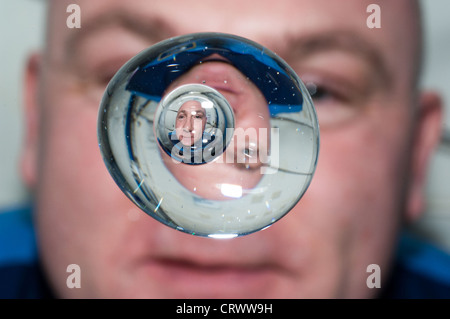 ESA-Astronauten André Kuipers Uhren eine Wasser-Blase zeigt sein Spiegelbild schweben frei in der Schwerelosigkeit an Bord der internationalen Raumstation ISS 24. Juni 2012. Stockfoto