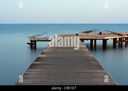 Langzeitbelichtung auf hölzernen Pier im Morgengrauen Stockfoto