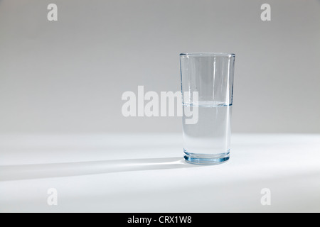 Glas halb voll oder halb leer mit Wasser Stockfoto