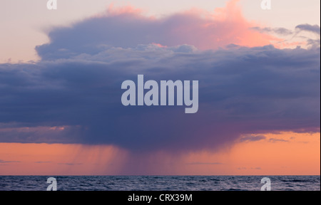 Schwere Regenwolken bei Sonnenuntergang über dem Ärmelkanal, gesehen von der Küste von Dorset. Frühling (April) 2012. Stockfoto