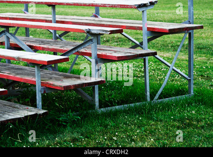 Isolierten roten Holz bleicher Bank auf grüner Wiese mit Textfreiraum. Stockfoto