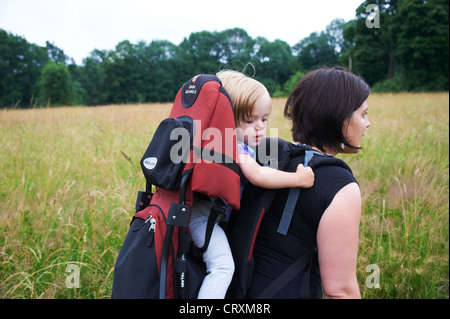 Eine Frau Mutter trägt ihr Kind in einem Outdoor-Rucksack Stockfoto