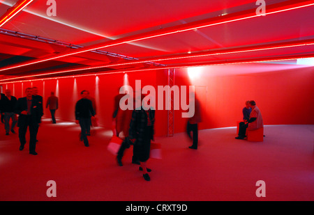 Menschen gehen durch ein rotes Zahnrad, e.on-Hauptversammlung in Essen Stockfoto