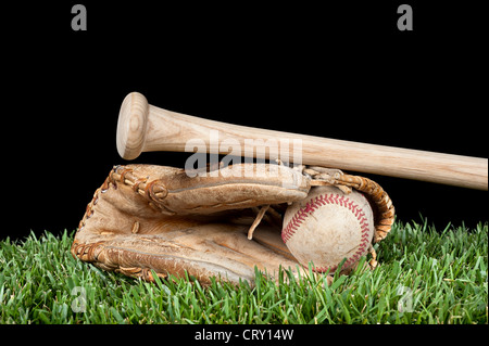 Baseball-Handschuh, Ball und Schläger, die Verlegung auf dem Rasen mit einem schwarzen Hintergrund für die Platzierung der Kopie. Stockfoto