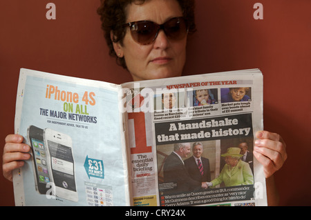 Frau liest eine Kopie des i unabhängige Zeitung Stockfoto