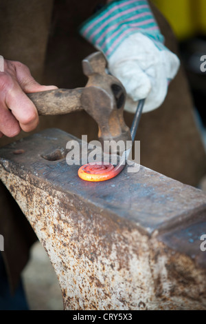 Schmied, dekorative Eisenarbeit mit Hammer und Amboss Stockfoto