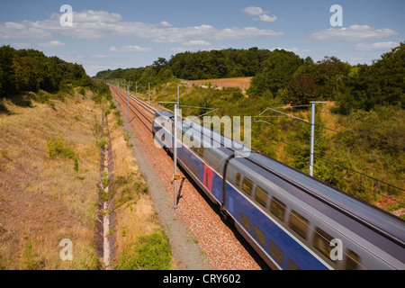 Ein Doppeldecker TGV beschleunigt durch die französische Landschaft. Stockfoto