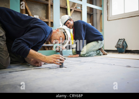 Bauherren, die mit einem Kreuz Linienlaser Stockfoto