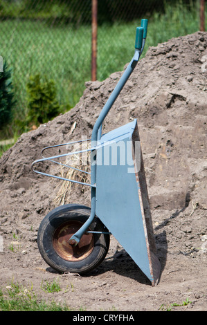 Schubkarre auf dem Hintergrund der Hügel des Sandes Stockfoto