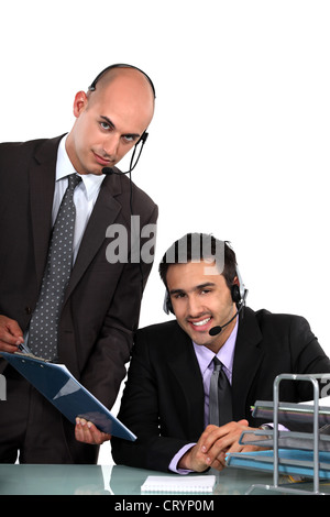 Zwei männliche Callcenter-Mitarbeiter Stockfoto