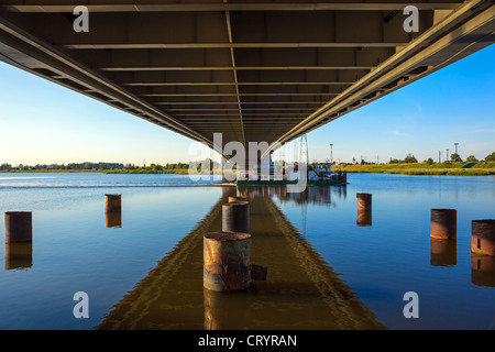 Schlepper auf den Drücker-Typ fließt unter der Brücke. Stockfoto