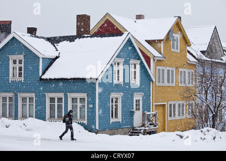 Mann geht vorbei an traditionellen Holzhäuser entlang Storgata in die malerische Gegend von Tromsø, am Polarkreis in Nord-Norwegen Stockfoto