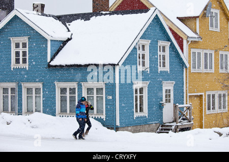 Paar Spaziergang, vorbei an traditionellen Holzbauten auf storgata in der malerischen Gegend von Tromsø, in der Arktis im Norden von Norwegen Stockfoto