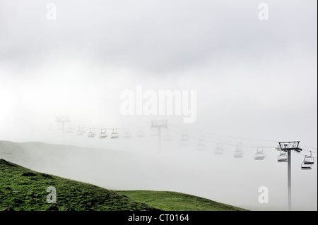 Leere Sessellift im desolaten Skigebiet im Sommer im Nebel bei Sonnenaufgang entlang der Col du Tourmalet in den Pyrenäen, Frankreich Stockfoto