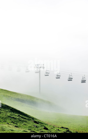 Leere Sessellift im desolaten Skigebiet im Sommer im Nebel bei Sonnenaufgang entlang der Col du Tourmalet in den Pyrenäen, Frankreich Stockfoto