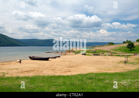 Weiße baktrischen Kamel (Camelus Bactrianus) in der Nähe von das Boot am Ufer der Angara. Siedlung Talzy, Irkutsk Region, Baikalsee, Sibirien Stockfoto