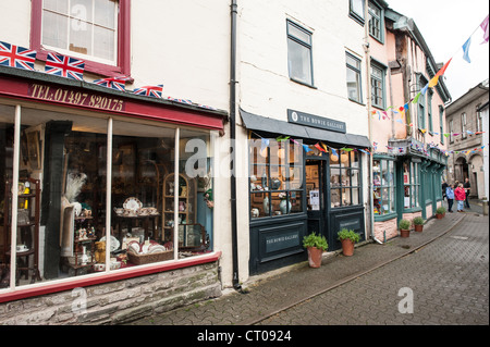 Buchhandlungen in Hay-on-Wye Wales // HEY-ON-WYE, Wales — Geschäfte säumen die Straßen von Hay-on-Wye in Powys, einer Stadt, die Synonym für den Antiquariat- und Antiquariatshandel am Südufer des Flusses Wye an der walisisch-englischen Grenze ist. Die Identität der Stadt als „die Stadt der Bücher“ wurde 1962 geschmiedet, als Richard Booth die erste Second-Hand-Buchhandlung in einer ehemaligen Feuerwache eröffnete und den Handel baute, bis schätzungsweise eine Million Bücher eine Gemeinde von weniger als 2.000 Menschen füllten. Am 1. April 1977 erklärte Booth ein „unabhängiges Königreich von Hay“ – er krönte sich selbst und ernannte sein Pferd zum König Stockfoto