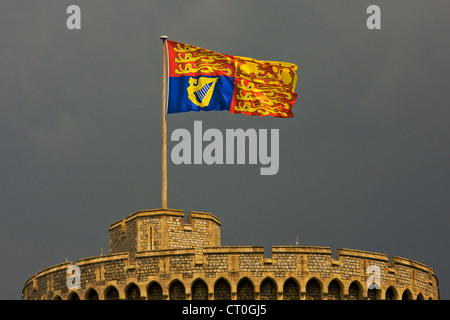 Spezielle große zeremonielle königliche Standarte Flagge aus dem Rundturm auf Schloss Windsor mit dunklen Gewitterwolken. JMH6023 Stockfoto