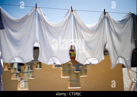 Weiße Kleidung an die Wäscheleine hängen. Stockfoto